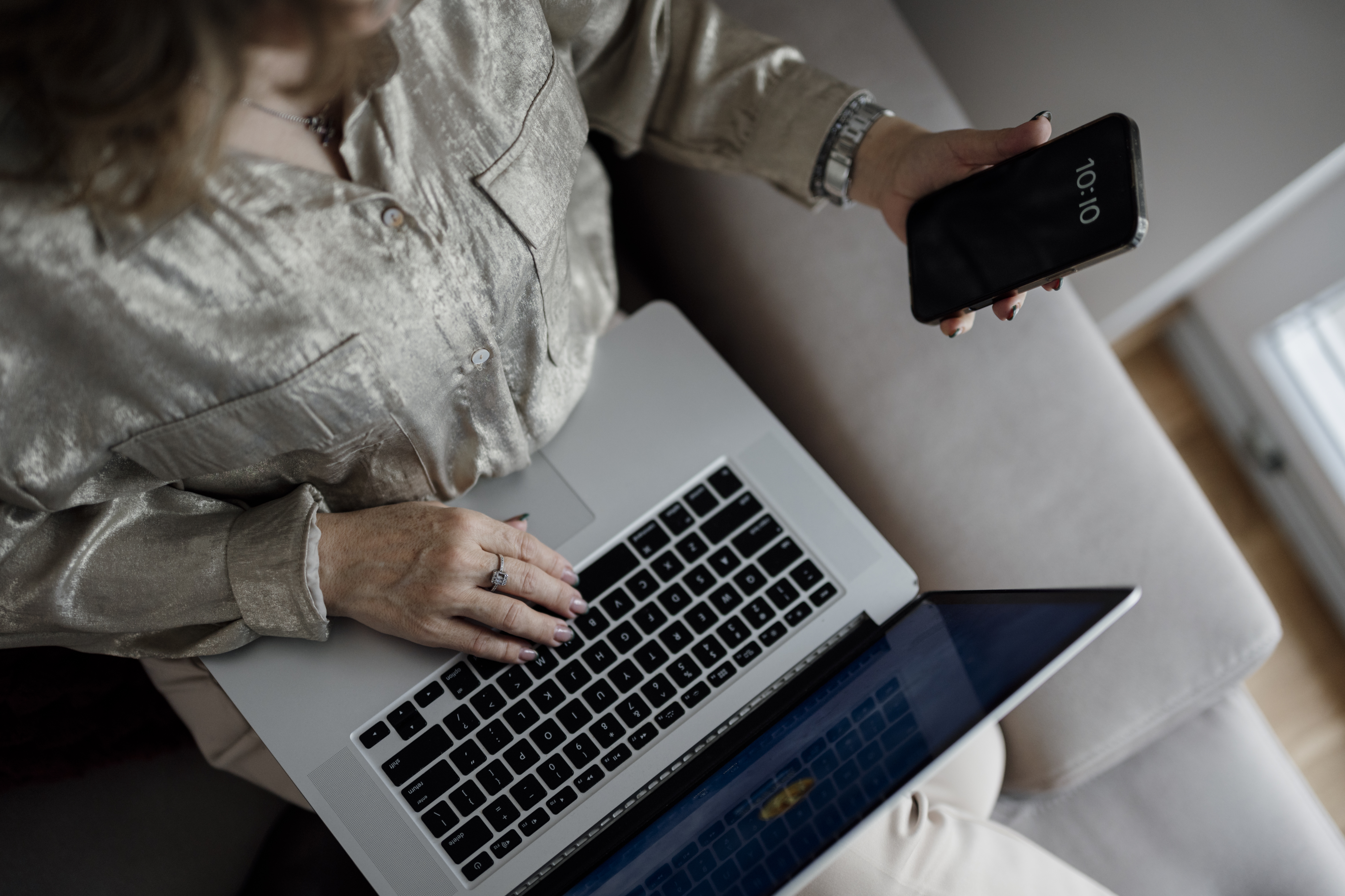 Person reviewing local lead sources on a smartphone while working on a laptop